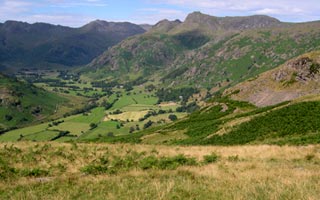 Great Langdale below and the Langdale Pikes. About this time AJM and SAM are climbing up Pavey Ark along Jack's Rake. From right to left, Pavey Ark, Harrison Stickle, Pike o' Stickle and Loft Crag. Distant Bowfell and Crinkle Crags.